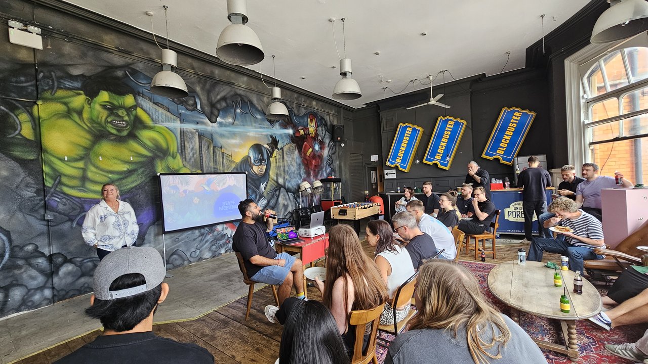 Staff meeting at Pete's Pizza with staff sat in chairs and watching projector screen