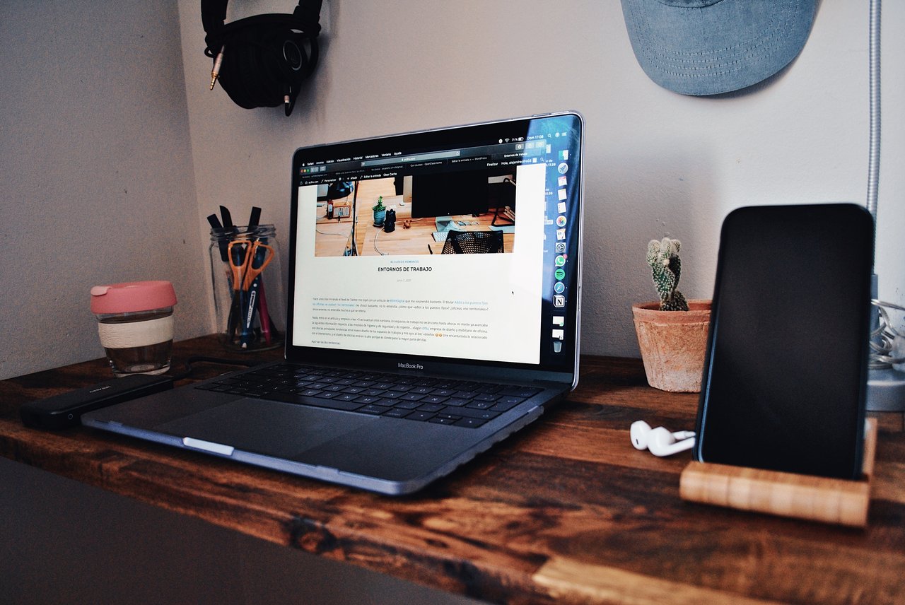 A desk set up with a laptop, the screen showing a live website.